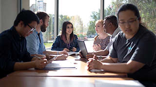 Students sitting around a table studying and talking.