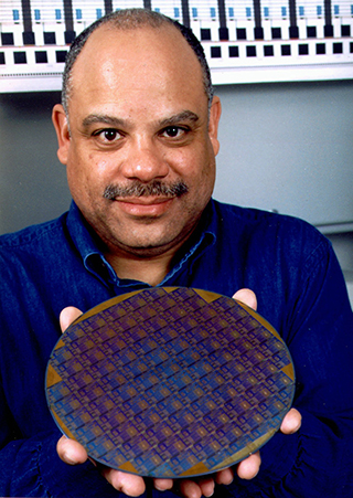 Image of Mark Dean holding the first one-gigahertz computer processing chip